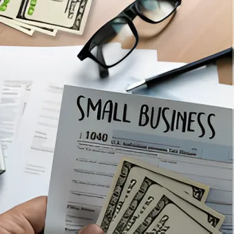 Modulo di finanziamento per piccole imprese con banconote, occhiali e una penna